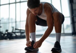 Um corredor ajustando meias e tênis antes de um treino